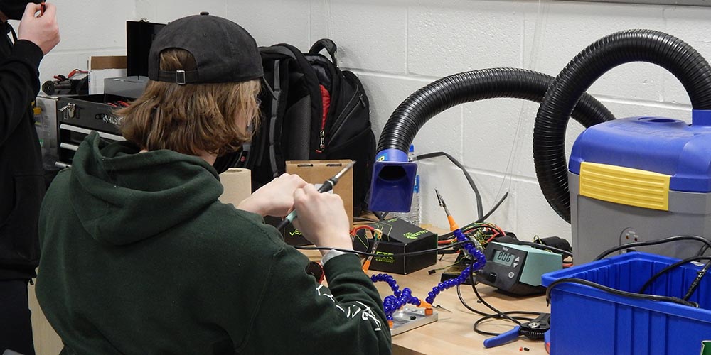 A picture of a student soldering.